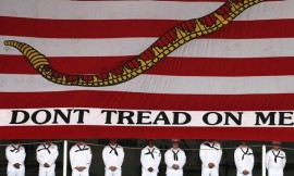 US navy sailors line up in front of the First Navy Jack flag during the USS Kitty Hawk Departure Ceremony, August 2008.